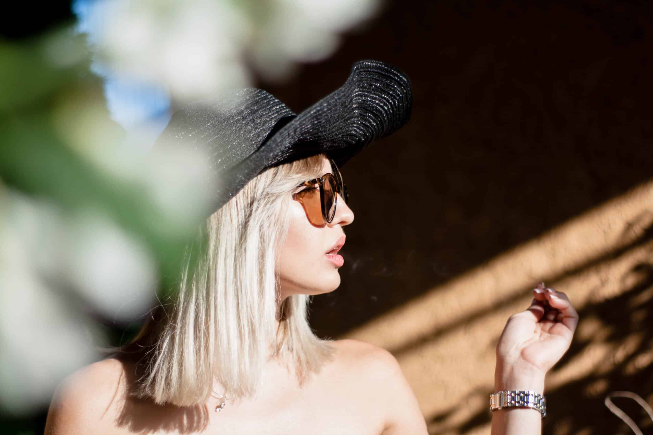 Woman Wearing a Hat and Sunglasses